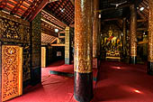 Wat Xieng Thong temple in Luang Prabang, Laos. The sim s interior is extensively decorated with intricate gold stencilling on black lacquer. Large stencilled teak wood pillars support the roof.  